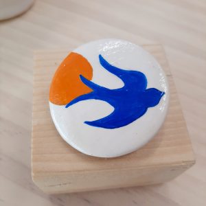 Κεραμική καρφίτσα στρογγυλή,ζωγραφισμένη στο χέρι με θέμα χελιδόνι